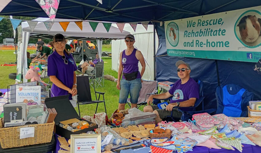 Three Cavy Corner volunteers on a stand at Honley Show